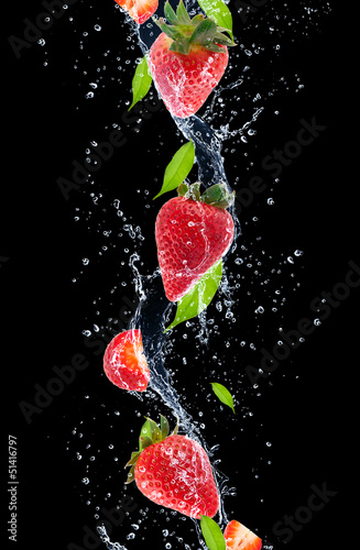 Obraz w ramie Strawberries in water splash, isolated on black background