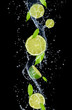 Limes in water splash, isolated on black background 