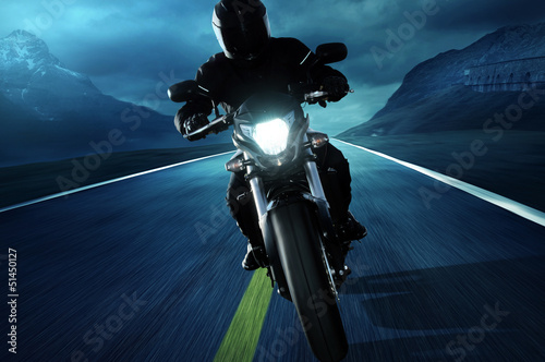 Fototapeta na wymiar Motocyklista na ulicy nocą