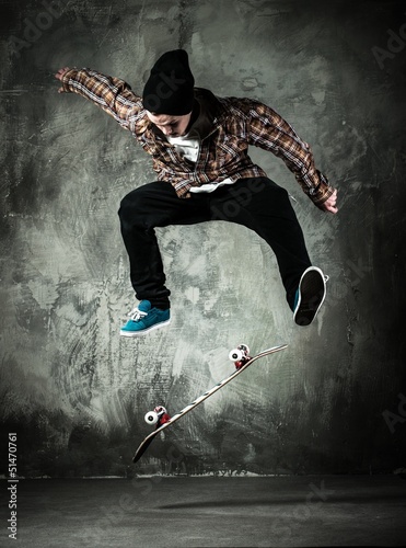 Naklejka na szybę Young man in hat and shirt performing stunt on skateboard