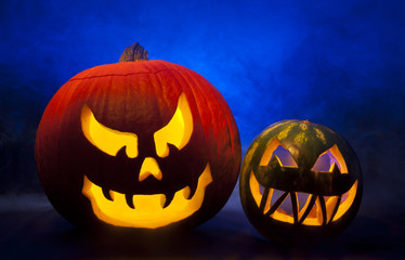 Halloween carved pumpkin and watermelon with blue foggy background