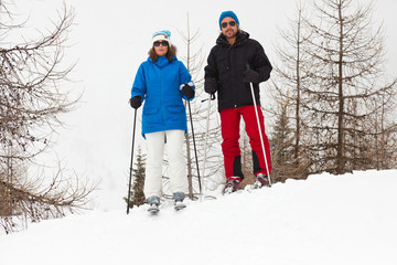 Happy ski couple standing on snow mountain.