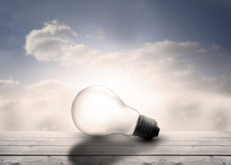 Poster - Light bulb resting on floorboards in the sky