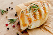 Grilled chicken breast with rosemary on wooden background