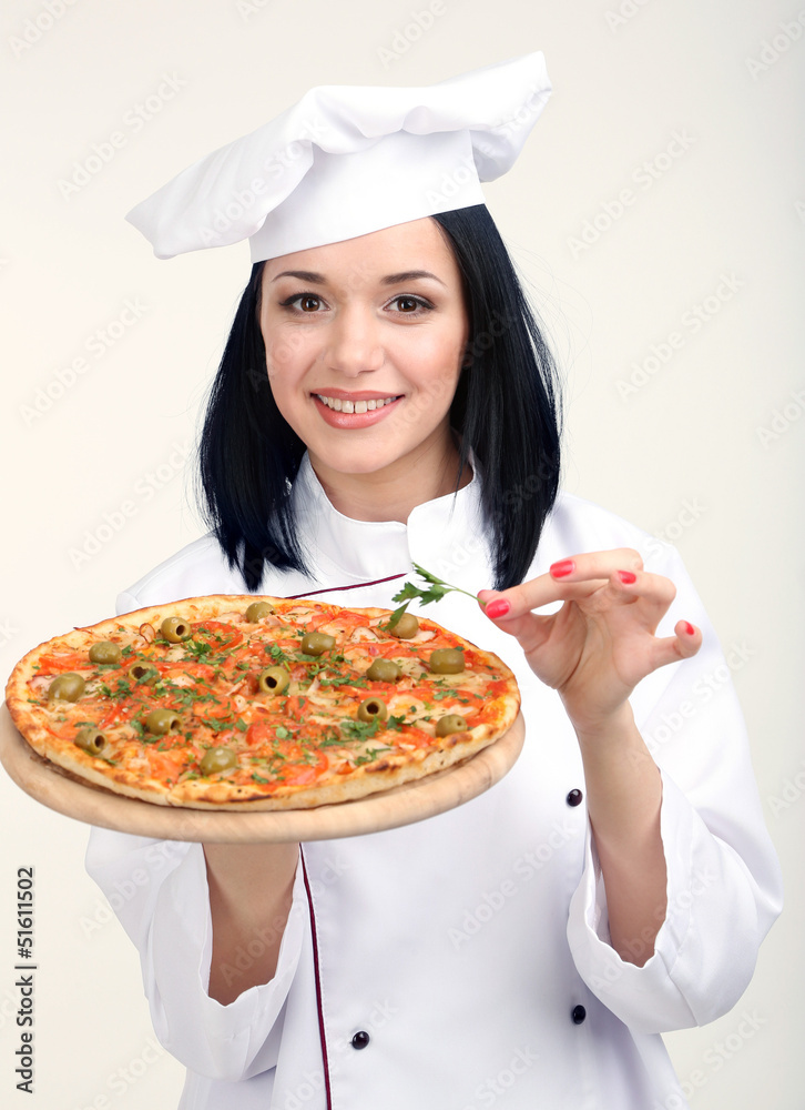 Beautiful girl chief-cooker with pizza isolated on white