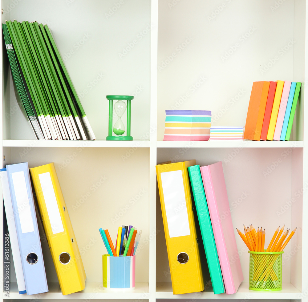 White office shelves with different stationery, close up