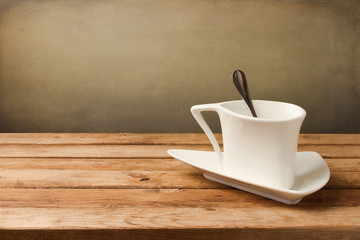 White coffee cup on wooden table over grunge background