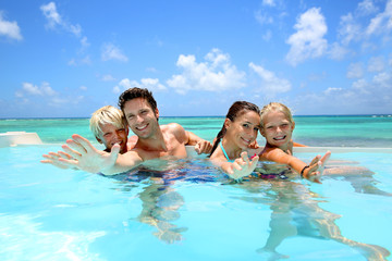 Wall Mural - Family of four bathing in swimming pool