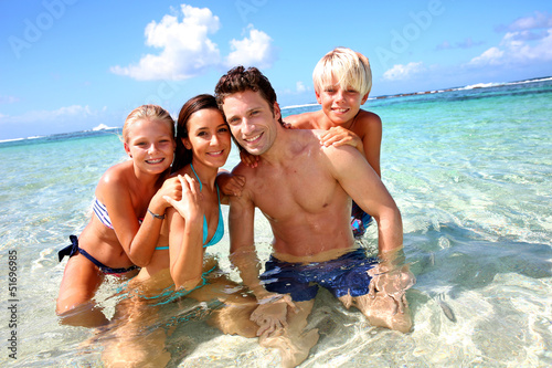 Fototapeta na wymiar Couple and children in crystal clear water