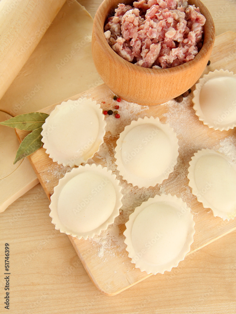 Raw dumplings and ingredients on wooden table