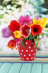 Poster - Beautiful tulips in bouquet on table on bright background