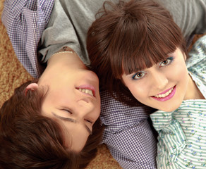 Closeup of happy young couple lying on floor. Top view