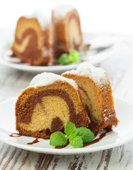 Vanilla and chocolate cake sliced with mint laves  on wooden tab