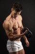 © Andrey Bandurenko - Muscular young man lifting a dumbbell