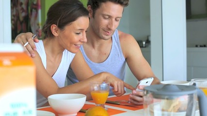 Wall Mural - Couple looking at internet while having breakfast