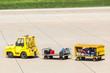 Yellow Freight trolleys with loaded baggage on the runway tarmac