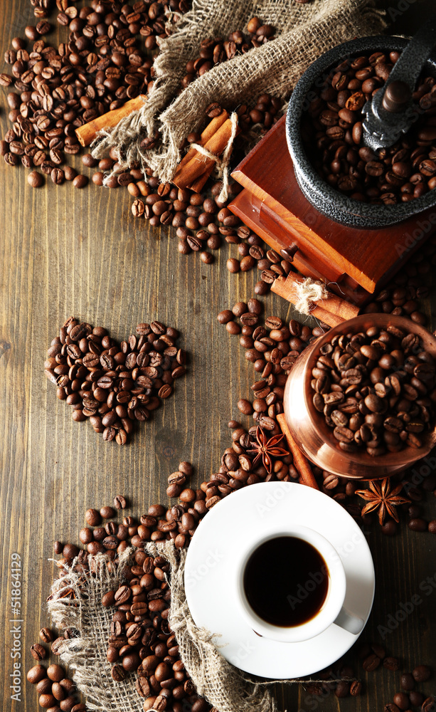 Cup of coffee, pot and grinder on wooden background
