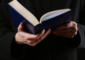 Wall Mural - Priest reading from the holy bible, close up