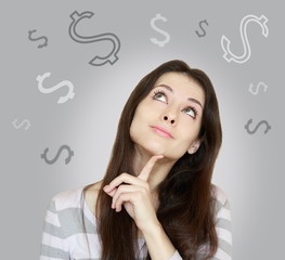 Young woman thinking about money and looking up on grey backgrou