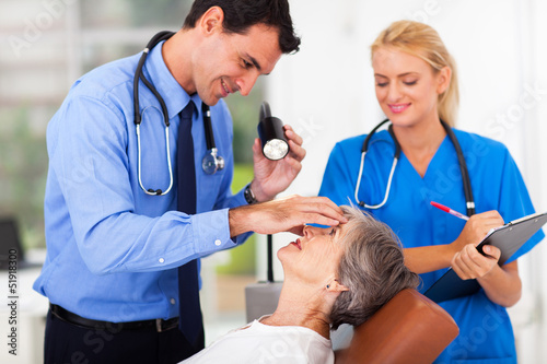 Fotografía ophthalmologist examining senior woman's eye