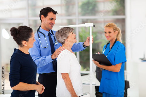 Fotografía general practitioner measuring senior patient's height