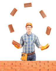 Sticker - Construction worker juggling with bricks behind a brick wall