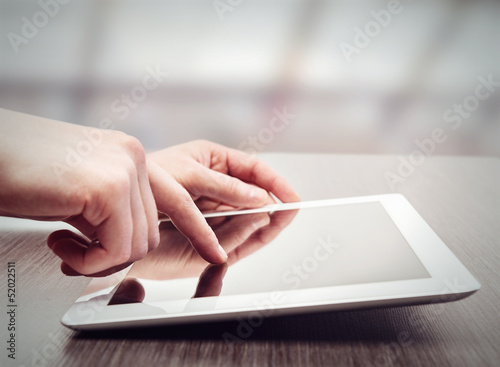 Fotografia white tablet with a blank screen in the hands on table