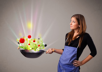 Wall Mural - Young woman cooking fresh vegetables