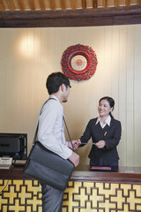 Businessman at Reception Desk of Hotel