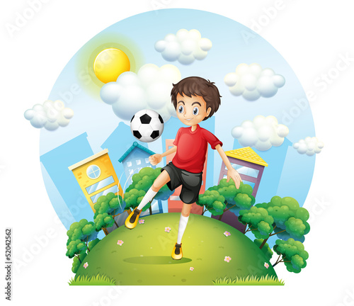 Plakat na zamówienie A soccer player practicing near the high buildings