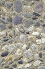 Stones Embedded In Concrete With Loose Pebbles