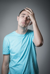 Wall Mural - Desperate young man covering with his head in his hands