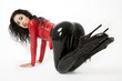Sexy flexible brunette woman in black and red latex and boots