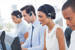 © WavebreakmediaMicro - Smiling call center employees sitting in line
