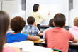 © Monkey Business - Teacher Standing In Class Using Interactive Whiteboard
