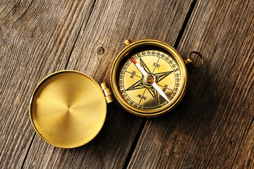 Antique compass over wooden background