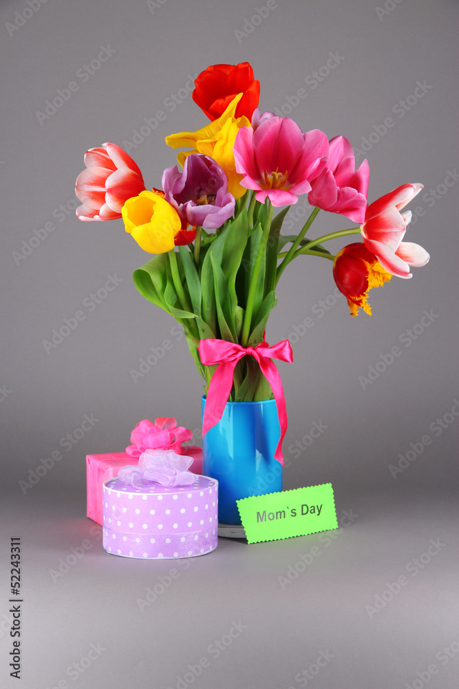 Beautiful tulips in bouquet with gifts and note