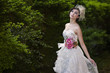 Attractive bride in white dress at park