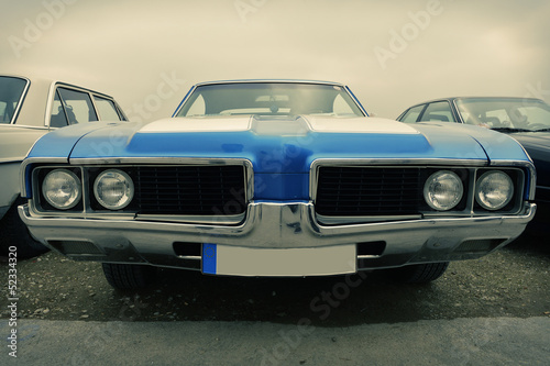 Fototapeta na wymiar Front of old sport car in blue, sixties style, retro
