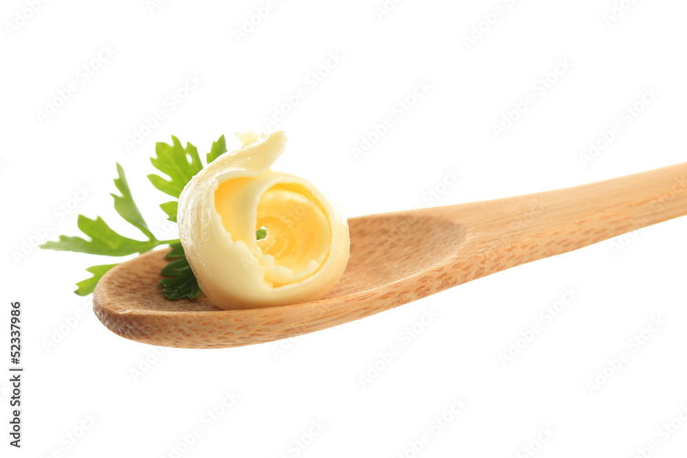 Butter curl on wooden spoon, isolated on white