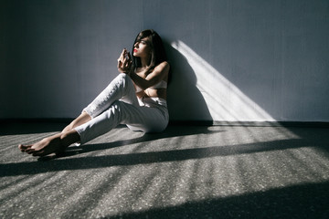 Woman wearing white jeans and lingery lying