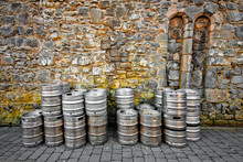 Stack Of Beer Kegs Against A Rustic Stone Wall