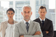 © WavebreakmediaMicro - Serious businessman standing with colleagues behind