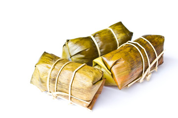 Wall Mural - Sweets wrapped in banana leaves on a white background