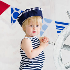 Cute little boy in the striped vest and sailor hat