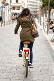 Fototapeta Miasto - Woman cycling down the street
