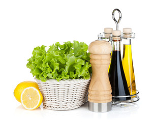 Wall Mural - Lettuce in basket with lemon fruits, pepper shaker, olive oil an