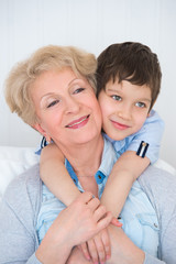 Wall Mural - Lovely little boy with his grandmother having fun and happy mome