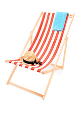 Wall Mural - Studio shot of a sun lounger with towel, hat and sunglasses