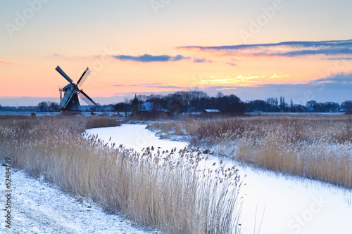 Fototapeta na wymiar Dutch windmill in winter at sunrise